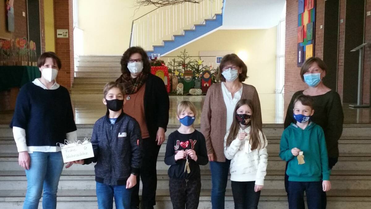Lehrer und Schüler vor Weihnachtskrippe bei Engelsübergabe Grundschule Laberweinting